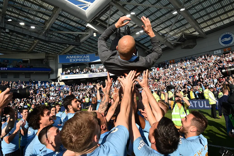 

Para pemain, pelatih, official dan suporter dari Manchester City larut dalam pesta gelar juara Liga Inggris 2018/2019 di markas Brighton. (Sumber: AFP/Glyn Kirk)