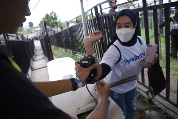 
Seorang Bobotoh wanita saat scan tiket di pintu masuk Stadion GBLA. (Foto: @PERSIB.co.id)