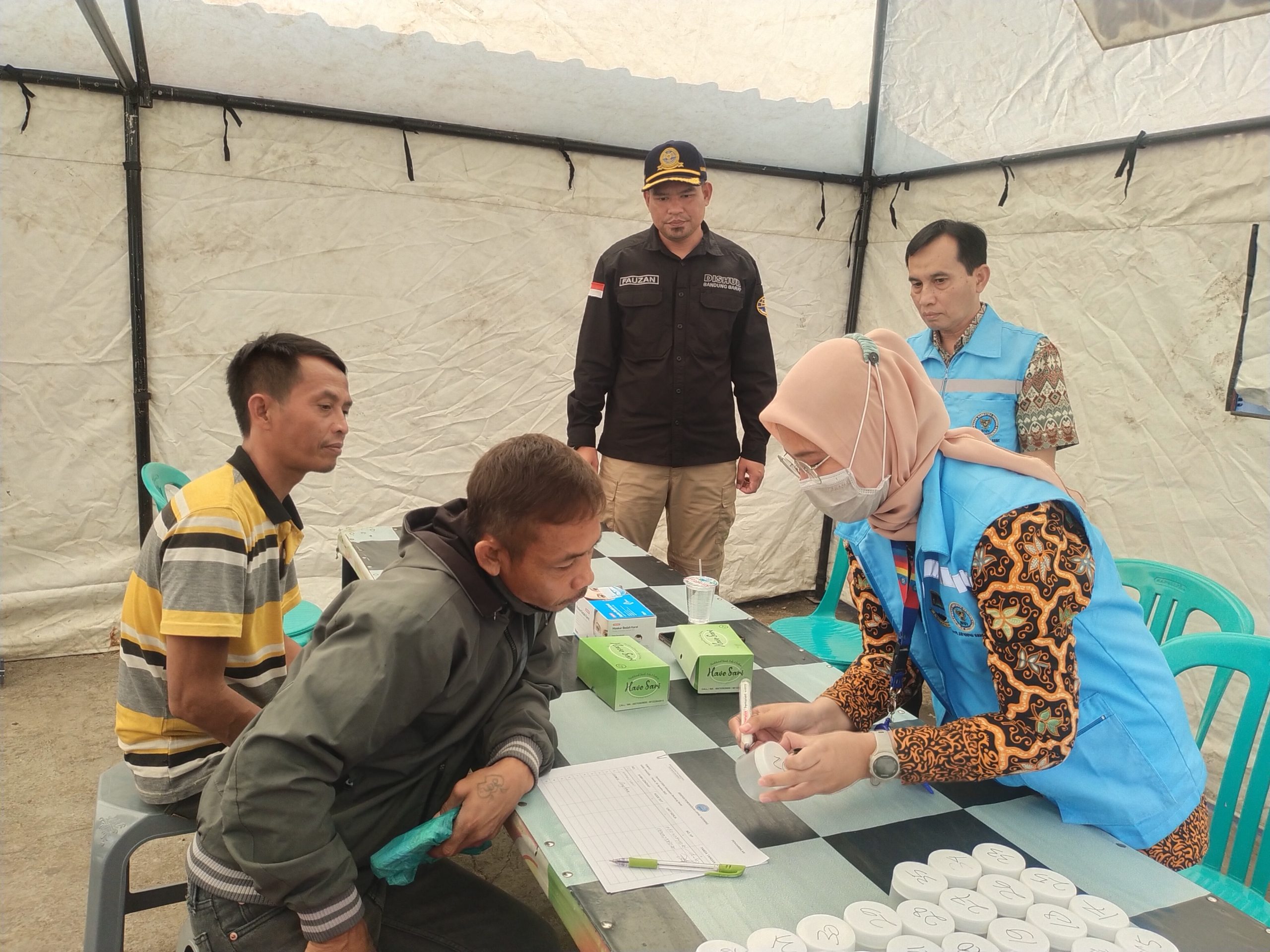 
Petugas dari Dinas Kesehatan Kabupaten Bandung sedang memeriksa sopir angkutan kota sebelum tes urine. (Foto: heny/dara)
