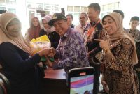 Arsan Latif secara simbolis menyerahkan  beras murah pada saat Bazar Beras Murah di Kecamatan Ngamprah (Foto: Istimewa)