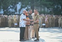 
Penjabat Gubernur Jawa Barat Bey Machmudin menyalami ASN yang menerima SK Pensiun, Piagam Penghargaan, Tabungan Hari Tua dan KTP Elektronik di halaman depan Gedung Sate, Kota Bandung, Senin (5/8/2024).(Foto: Biro Adpim Jabar)