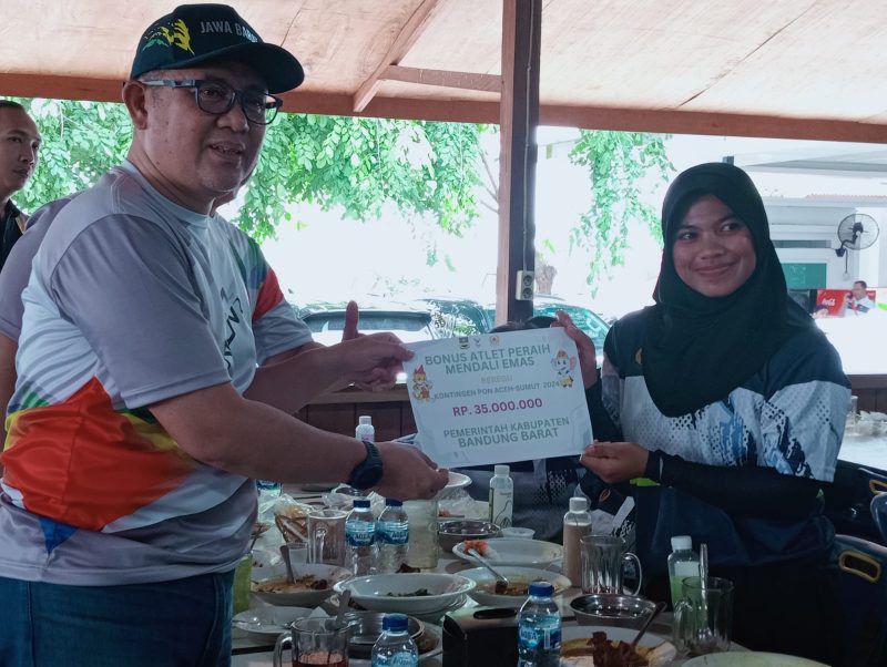 Ade Zakir secara simbolis memberikan bonus kepada atlet Dayung putri yang berhasil meraih medali emas pada PON XXI (Foto: Istimewa)