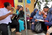 
Calon Bupati Garut dr. Helmi Budiman, nampak asyik menikmati sarapan pagi sambil berbincang-bincang dengan warga dan Kader Posyandu di Alun-alun Pameungpeuk, Kabupaten Garut, Kamis (31/10/2024).(Foto: andre/dara) 
