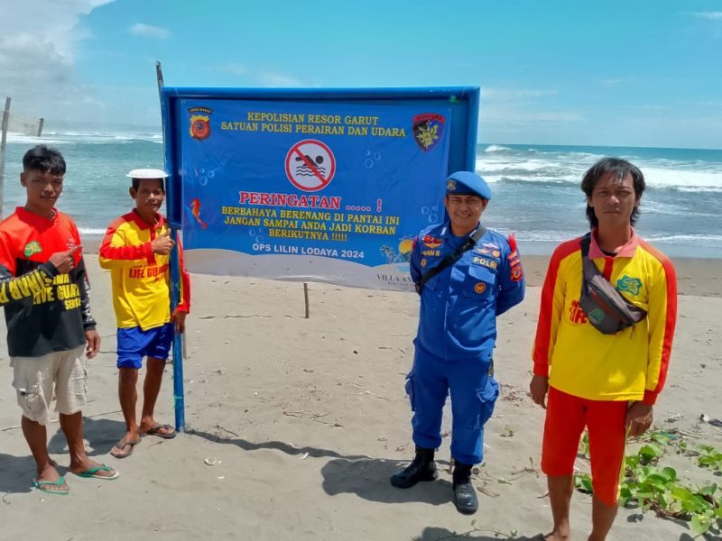 Satpolairud Polres Garut bersama BKO Dit Polairud Polda Jabar dan Balawisata memasang spanduk peringatan tanda bahaya di objek wisata Pantai Sayang Heulang, Kecamatan Pameungpeuk, Kabupaten Garut pada Senin (23/12/2024)(Foto: Istimewa)