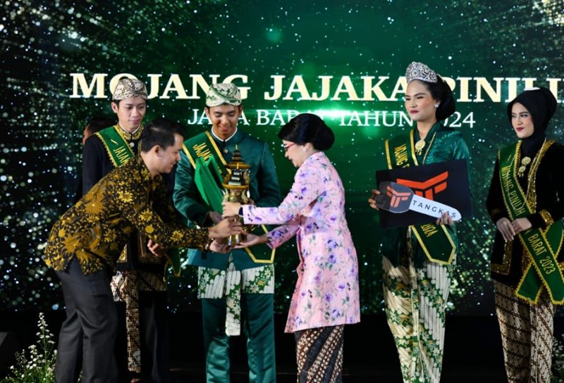 
Penjabat Ketua TP PKK Jawa Barat Amanda Soemedi Bey Machmudin memberikan piala kepada juara Mojang Jajaka Jawa Barat 2024 di Gedung Merdeka, Kota Bandung, Ahad (15/12/2024) malam.(Foto: biro adpim jabar).
