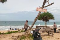 
Personel Polsek Cikelet, Polres Garut, melakukan pengamanan di Pos Pam Wisata Pantai Santolo, Kecamatan Cikelet, Kabupaten Garut, Kamis (2/1/2025).(Foto: andre/dara)
