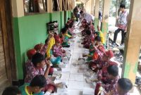 
Murid SDN Citalaksana Cangkuang, Kabupaten Bandung, Jawa Barat mekan nasi dus besama di teras kelas saat uji coba program makan bergizi gratis,belum lama ini.(Foto: Ist)
