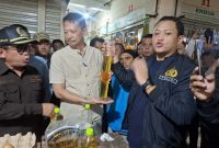 Kasat Reskrim Polres Cimahi bersama Kadisperindag KBB menunjukan hasil ukuran MinyaKita yang tidak sesuai dengan takaran tertera di packaging (Foto: Istimewa)