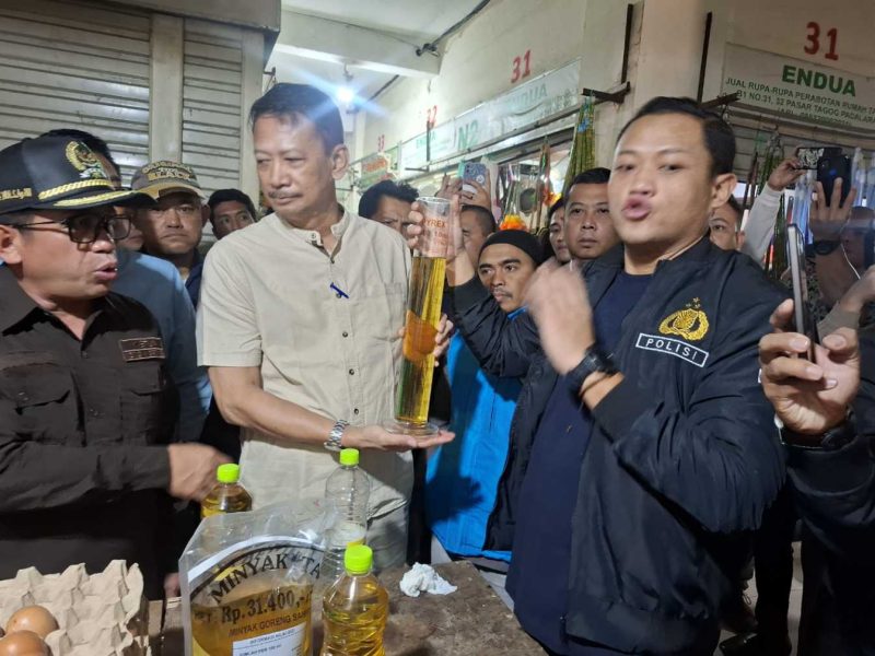 Kasat Reskrim Polres Cimahi bersama Kadisperindag KBB menunjukan hasil ukuran MinyaKita yang tidak sesuai dengan takaran tertera di packaging (Foto: Istimewa)